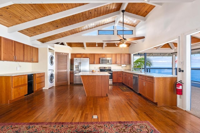 87-3181 Japonica Rd, Captain Cook, HI 96704 - kitchen featuring stainless steel appliances, stacked washing machine and dryer, dark wood-style flooring, brown cabinetry, and a kitchen island