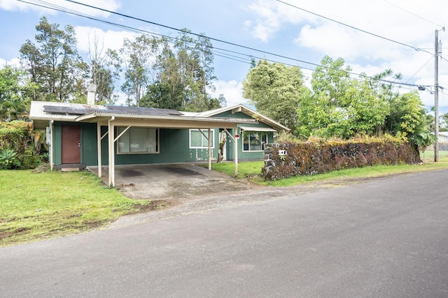 137 Kuakolu Pl, Hilo, HI 96720 - view of front of house featuring solar panels, a front yard, driveway, and an attached carport