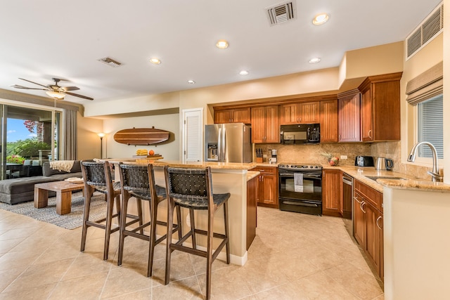 68-1376 Pauoa Rd Unit E1, Kamuela, HI 96743 - kitchen with black appliances, a kitchen island, decorative backsplash, light tile patterned floors, and light stone counters