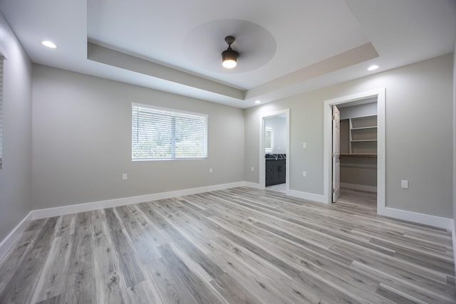 15-1776 6th Ave, Keaau, HI 96749 - unfurnished bedroom with a tray ceiling, light wood-style floors, a walk in closet, recessed lighting, and baseboards