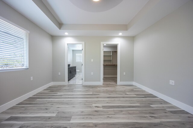 15-1776 6th Ave, Keaau, HI 96749 - unfurnished bedroom featuring ensuite bathroom, a walk in closet, light wood-style flooring, recessed lighting, and a tray ceiling