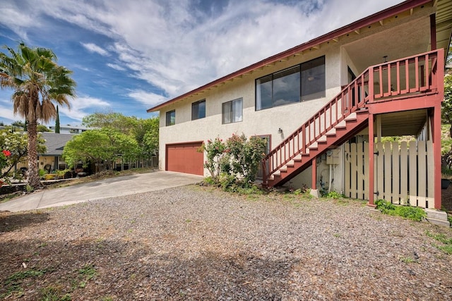 68-1780 Puu Nui St, Waikoloa, HI 96738 - view of home's exterior featuring a garage, stairway, stucco siding, and driveway