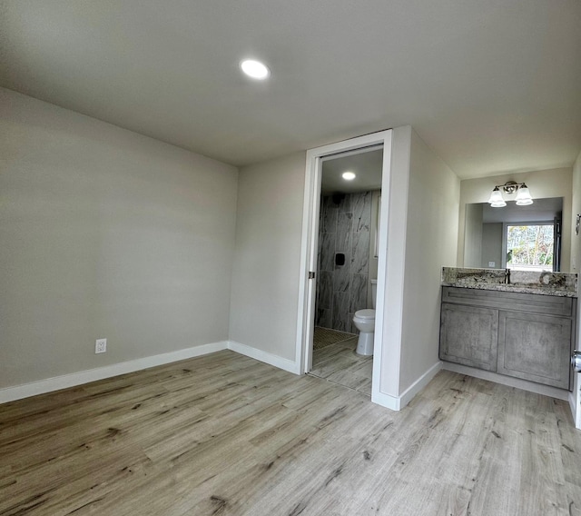 16-2045 Hanale Dr, Pahoa, HI 96778 - unfurnished bedroom featuring light wood-type flooring, baseboards, ensuite bath, recessed lighting, and a sink