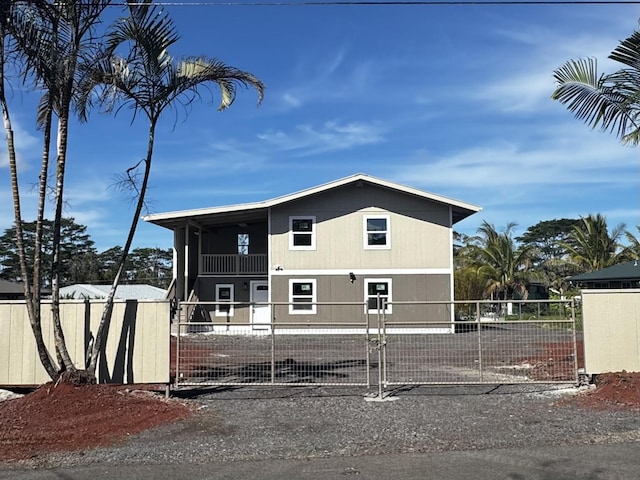 16-2045 Hanale Dr, Pahoa, HI 96778 - view of side of home featuring a balcony, a fenced front yard, and a gate