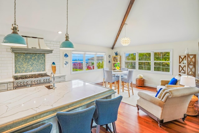 3764 Kakela Makai Dr, Kalaheo, HI 96741 - kitchen with light wood finished floors, backsplash, range with two ovens, light stone counters, and hanging light fixtures