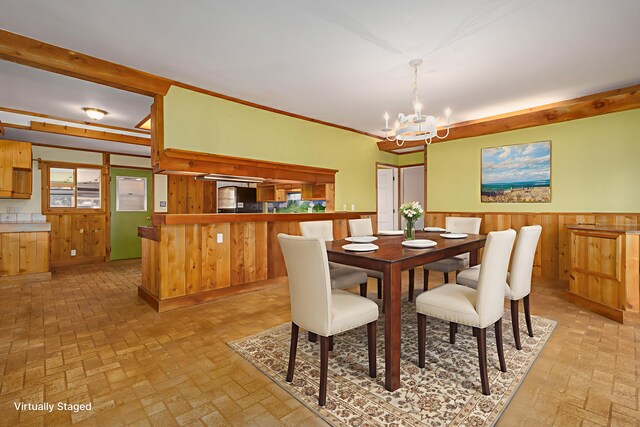 66-1665-A Kawaihae Rd, Kamuela, HI 96743 - dining area featuring a chandelier, brick patterned floors, a wainscoted wall, and wooden walls