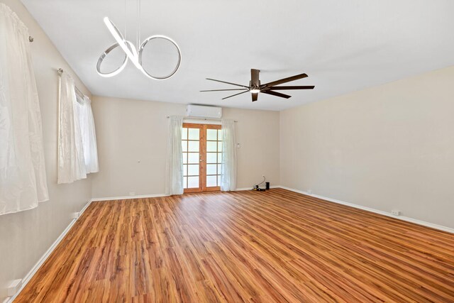 5045 Menehune Rd, Waimea, HI 96796 - unfurnished room featuring light wood-type flooring, a ceiling fan, a chandelier, and a wall mounted AC