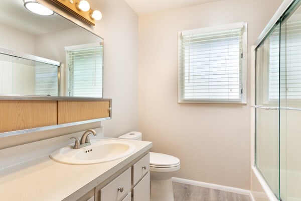 68-3750 Ua Noe Pl, Waikoloa, HI 96738 - full bath with toilet, vanity, wood finished floors, bath / shower combo with glass door, and baseboards