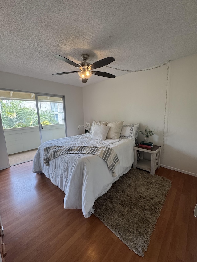 75-6008 Alii Dr Unit 234, Kailua-Kona, HI 96740 - bedroom with wood finished floors, a textured ceiling, access to exterior, a ceiling fan, and baseboards