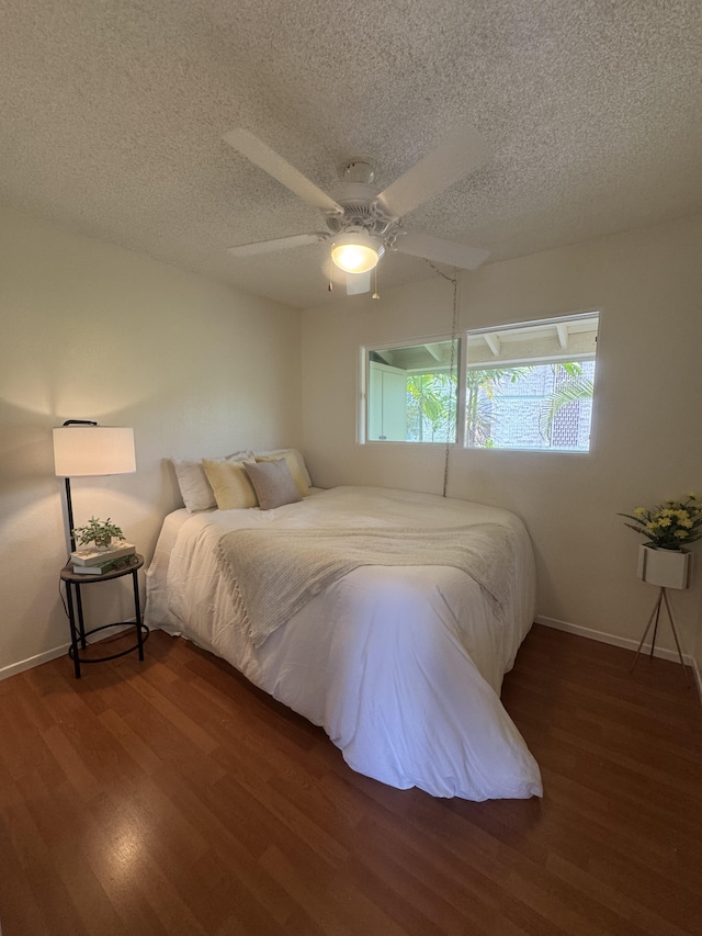 75-6008 Alii Dr Unit 234, Kailua-Kona, HI 96740 - bedroom featuring wood finished floors, a textured ceiling, baseboards, and ceiling fan