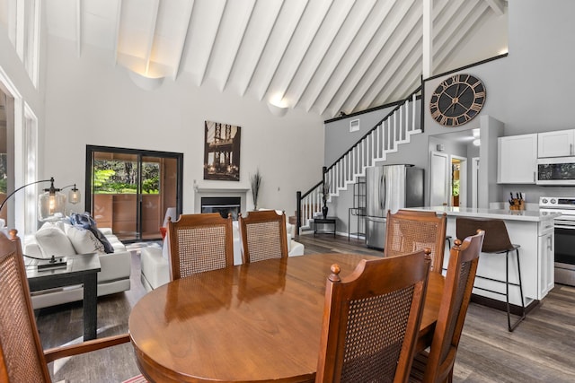 11-3827 5th St, Volcano, HI 96785 - dining area with high vaulted ceiling, a fireplace, dark wood finished floors, stairway, and beamed ceiling