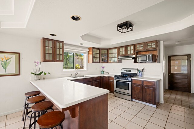 2640 Keoki Pl, Kalaheo, HI 96741 - kitchen featuring stainless steel appliances, a breakfast bar, under cabinet range hood, a peninsula, and light tile patterned floors