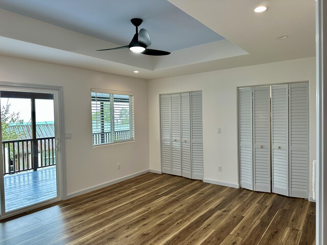 64-5304 Puu Nani Dr, Kamuela, HI 96743 - unfurnished bedroom featuring multiple closets, dark wood finished floors, access to exterior, a tray ceiling, and recessed lighting