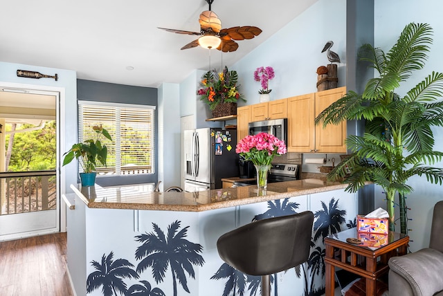 75-6009 Alii Dr Unit K22, Kailua-Kona, HI 96740 - kitchen featuring stainless steel appliances, light brown cabinetry, wood finished floors, healthy amount of natural light, and vaulted ceiling