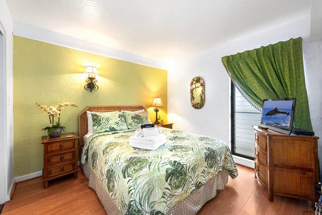 75-6082 Alii Dr Unit B236, Kailua-Kona, HI 96740 - bedroom featuring wood finished floors and a baseboard radiator