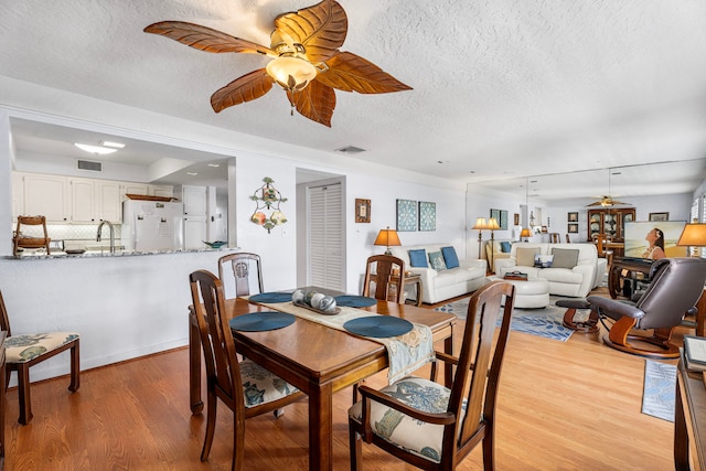 75-6082 Alii Dr Unit B236, Kailua-Kona, HI 96740 - dining space with ceiling fan, light wood-style floors, and a textured ceiling