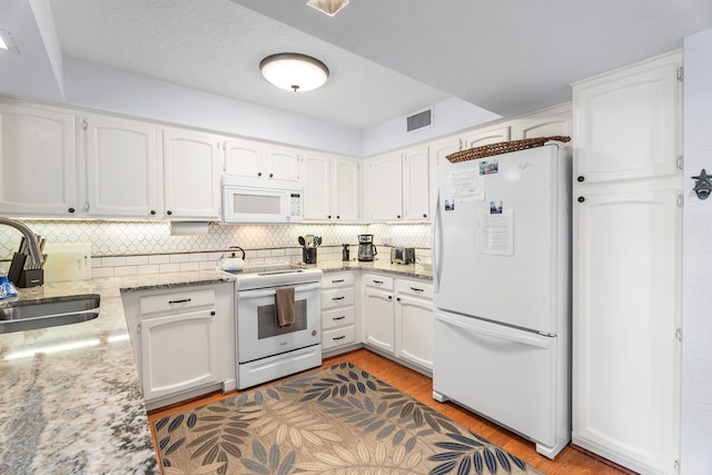 75-6082 Alii Dr Unit B236, Kailua-Kona, HI 96740 - kitchen with white appliances, white cabinetry, backsplash, light stone counters, and light wood-type flooring