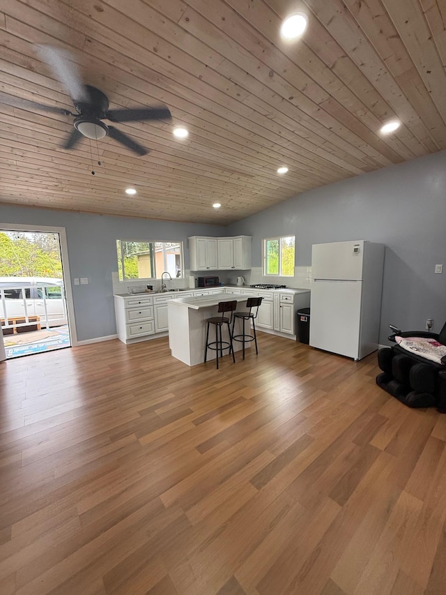 11-2828 Lehua St, Mountain View, HI 96771 - kitchen featuring freestanding refrigerator, light countertops, white cabinets, a breakfast bar area, and wooden ceiling