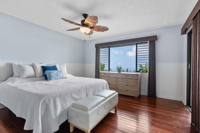 73-4332 Imo Pl, Kailua-Kona, HI 96740 - bedroom with wainscoting, dark wood-style floors, a textured ceiling, and ceiling fan