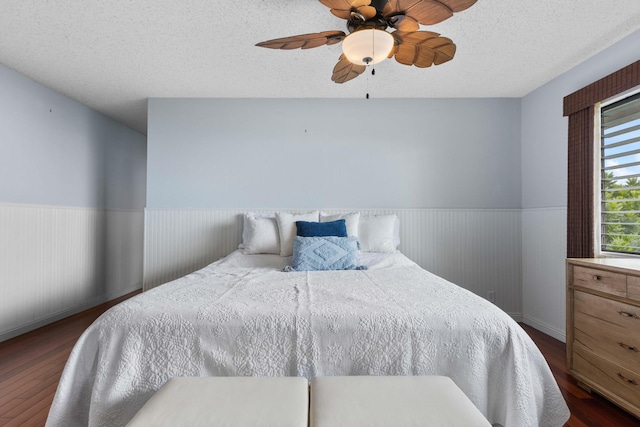 73-4332 Imo Pl, Kailua-Kona, HI 96740 - bedroom featuring wainscoting, dark wood-style flooring, a textured ceiling, and ceiling fan