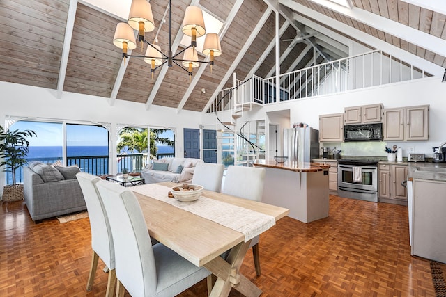 36-2333 Old Mamalahoa Hwy, Laupahoehoe, HI 96764 - dining room featuring high vaulted ceiling, a chandelier, stairway, a water view, and wood ceiling with exposed beams