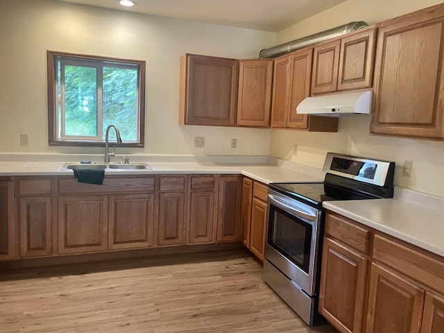 1370 Honoohala Pl, Kapaa, HI 96746 - kitchen featuring stainless steel range with electric cooktop, under cabinet range hood, a sink, light wood-style flooring, and brown cabinetry