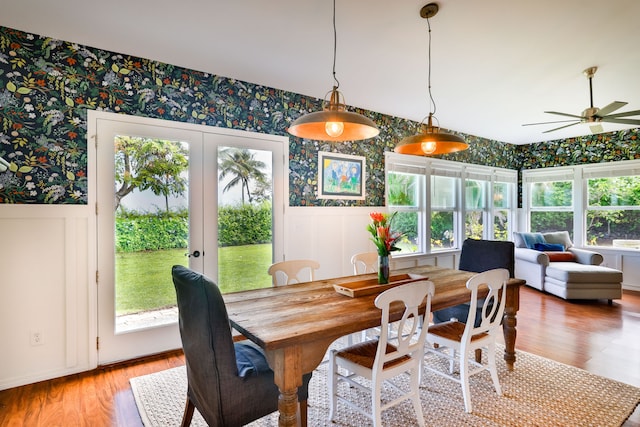 75-679 Kuahiwi Pl, Kailua-Kona, HI 96740 - dining room featuring wallpapered walls, wainscoting, ceiling fan, light wood finished floors, and french doors