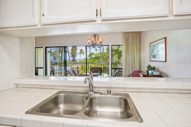 410 Papaloa Rd Unit 225, Kapaa, HI 96746 - kitchen featuring tile countertops, white cabinetry, a chandelier, and wallpapered walls