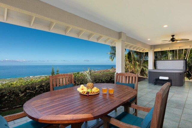 76-987 Aeo St, Kailua-Kona, HI 96740 - view of patio / terrace with a hot tub, ceiling fan, outdoor dining area, and a water view