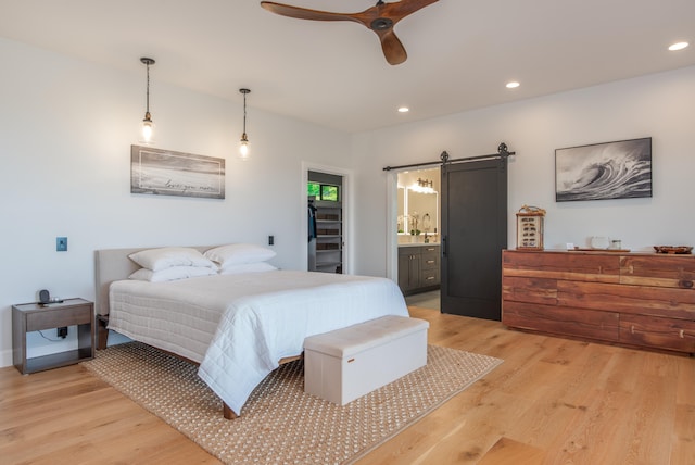 75-650 Halewili Pl, Kailua-Kona, HI 96725 - bedroom featuring a barn door, light wood-type flooring, recessed lighting, connected bathroom, and a ceiling fan