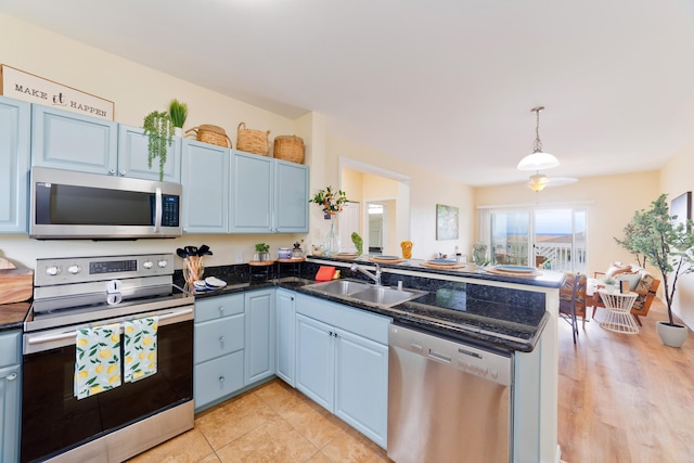 73-1102 Nuuanu Pl Unit F203, Kailua-Kona, HI 96740 - kitchen with stainless steel appliances, a peninsula, decorative light fixtures, blue cabinets, and dark stone countertops
