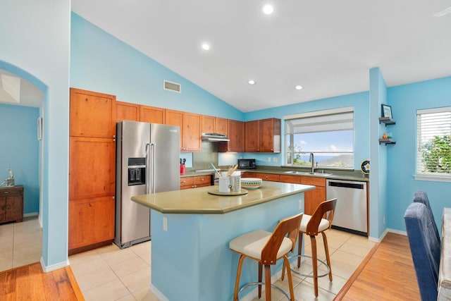 75-650 Mea Lanakila St, Kailua-Kona, HI 96740 - kitchen featuring appliances with stainless steel finishes, under cabinet range hood, a center island, a kitchen bar, and light wood-style floors