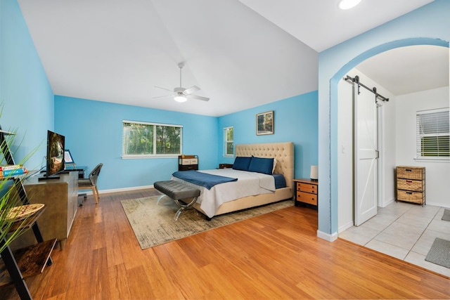 75-650 Mea Lanakila St, Kailua-Kona, HI 96740 - bedroom featuring a barn door, wood finished floors, arched walkways, ceiling fan, and vaulted ceiling