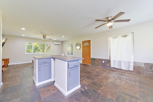 14-3385 Paradise Rd, Pahoa, HI 96778 - kitchen with ceiling fan, a wall unit AC, stone tile flooring, a center island, and recessed lighting