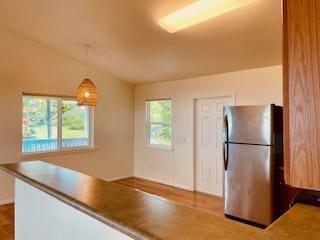 94-1654 Lewa Nuu St, Naalehu, HI 96772 - kitchen with freestanding refrigerator, hanging light fixtures, and wood finished floors