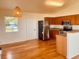 94-1654 Lewa Nuu St, Naalehu, HI 96772 - kitchen with appliances with stainless steel finishes, brown cabinets, wood finished floors, lofted ceiling, and pendant lighting