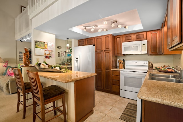 3880 Wyllie Rd Unit 21C, Princeville, HI 96722 - kitchen featuring white appliances, a tray ceiling, a kitchen breakfast bar, and brown cabinetry