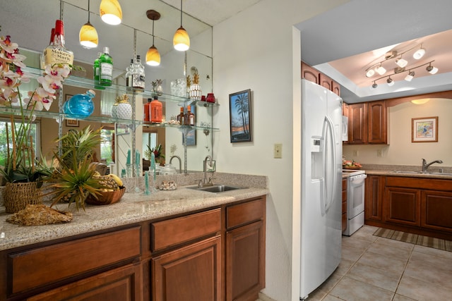 3880 Wyllie Rd Unit 21C, Princeville, HI 96722 - kitchen featuring white appliances, light tile patterned floors, brown cabinets, light stone countertops, and hanging light fixtures