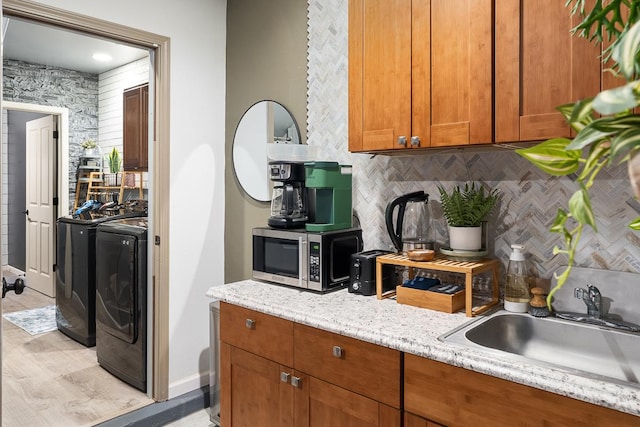 68-1846 Puu Nui St, Waikoloa, HI 96738 - kitchen with stainless steel microwave, washer and clothes dryer, backsplash, and brown cabinetry