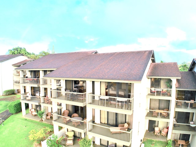 5380 Honoiki Rd Unit J33, Princeville, HI 96722 - back of house featuring roof with shingles, a balcony, and a patio area