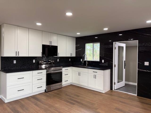 144 Chong St, Hilo, HI 96720 - kitchen with stainless steel range with electric stovetop, black microwave, dark countertops, decorative backsplash, and recessed lighting