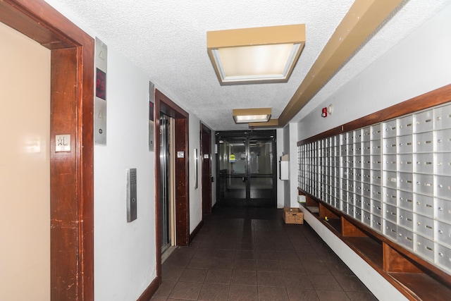 2916 Date St Unit 6F, Honolulu, HI 96816 - hallway with dark tile patterned floors, elevator, a textured ceiling, and mail area