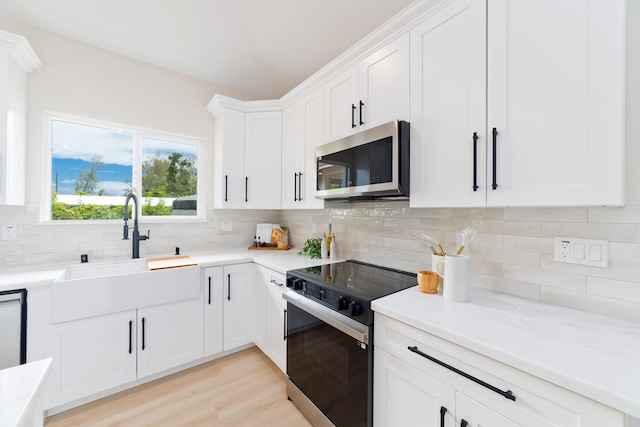 15-1955 Beach Rd, Keaau, HI 96749 - kitchen with range with electric stovetop, stainless steel microwave, decorative backsplash, and white cabinets