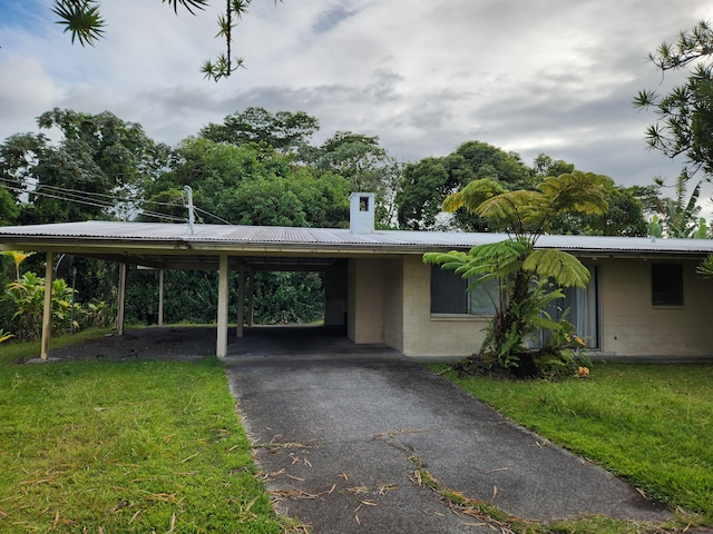15-1724 22nd Ave, Keaau, HI 96749 - view of front of home with concrete block siding, a chimney, an attached carport, and a front lawn