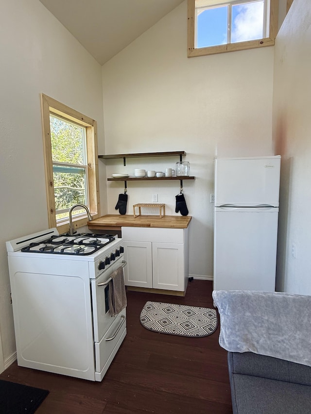 94 Pele St, Naalehu, HI 96772 - kitchen featuring white appliances, dark wood-style floors, wooden counters, white cabinetry, and open shelves