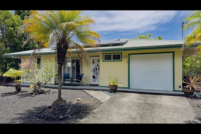 15-2811 Manalo St, Pahoa, HI 96778 - view of front of property with solar panels, a garage, a metal roof, driveway, and covered porch