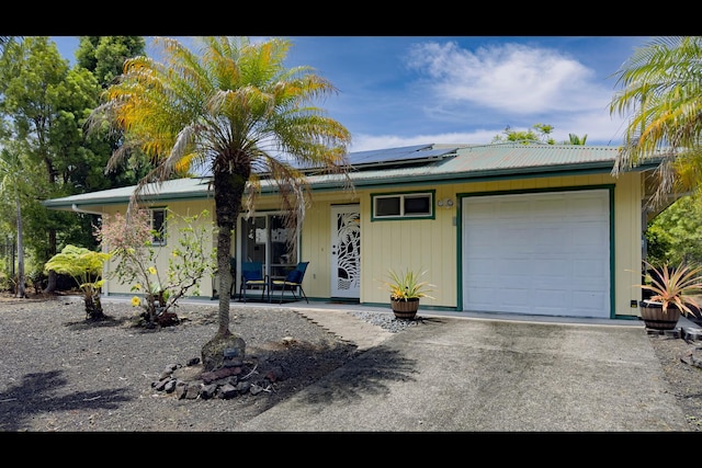15-2811 Manalo St, Pahoa, HI 96778 - view of front facade with a porch, solar panels, a metal roof, and a garage