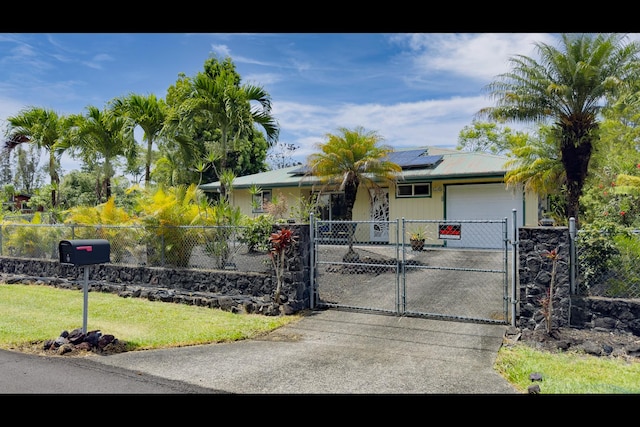 15-2811 Manalo St, Pahoa, HI 96778 - ranch-style home featuring driveway, an attached garage, a fenced front yard, roof mounted solar panels, and a gate