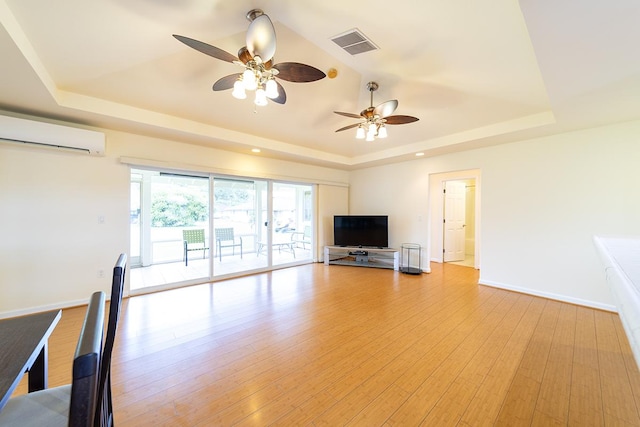 321 Noelani Loop, Hilo, HI 96720 - unfurnished living room with a raised ceiling, a wall mounted air conditioner, ceiling fan, light wood-style floors, and recessed lighting