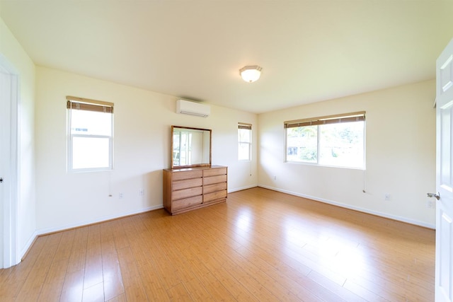 321 Noelani Loop, Hilo, HI 96720 - unfurnished bedroom featuring an AC wall unit and light wood-type flooring